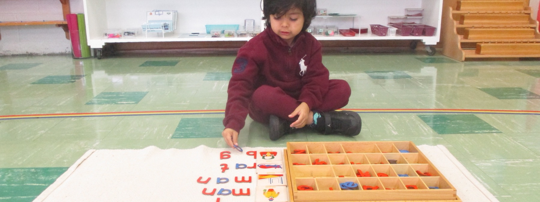 Child working independently with Montessori language materials in the classroom