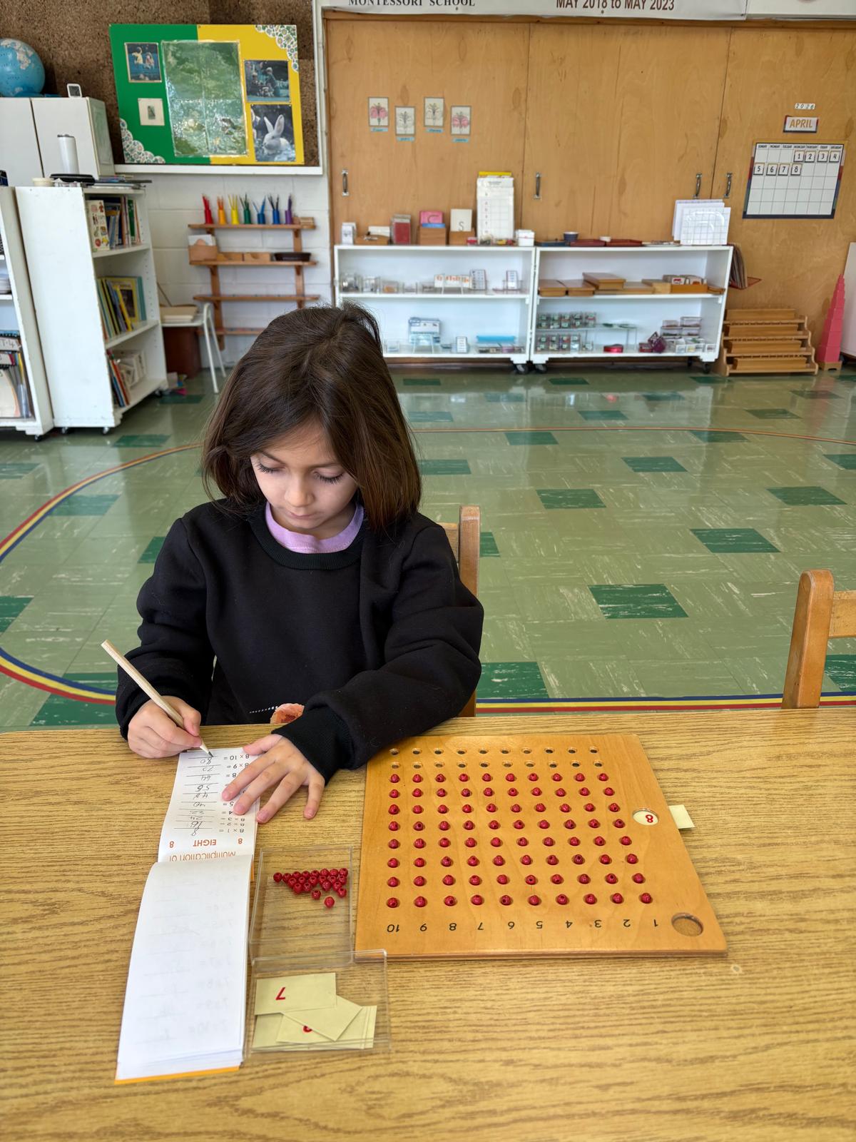Child working with a Montessori counting board and number materials