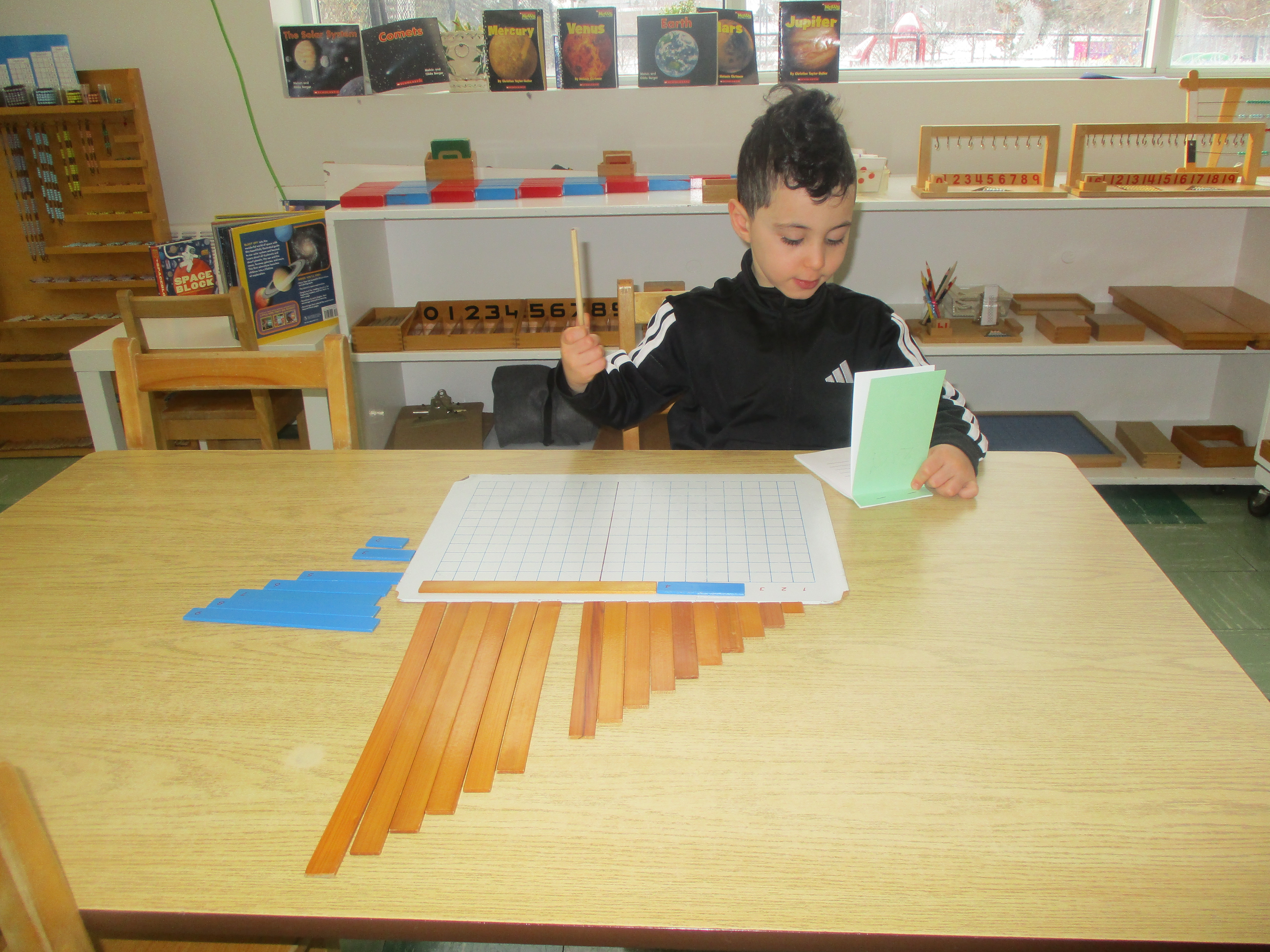 Child working with Montessori number rods and counting materials