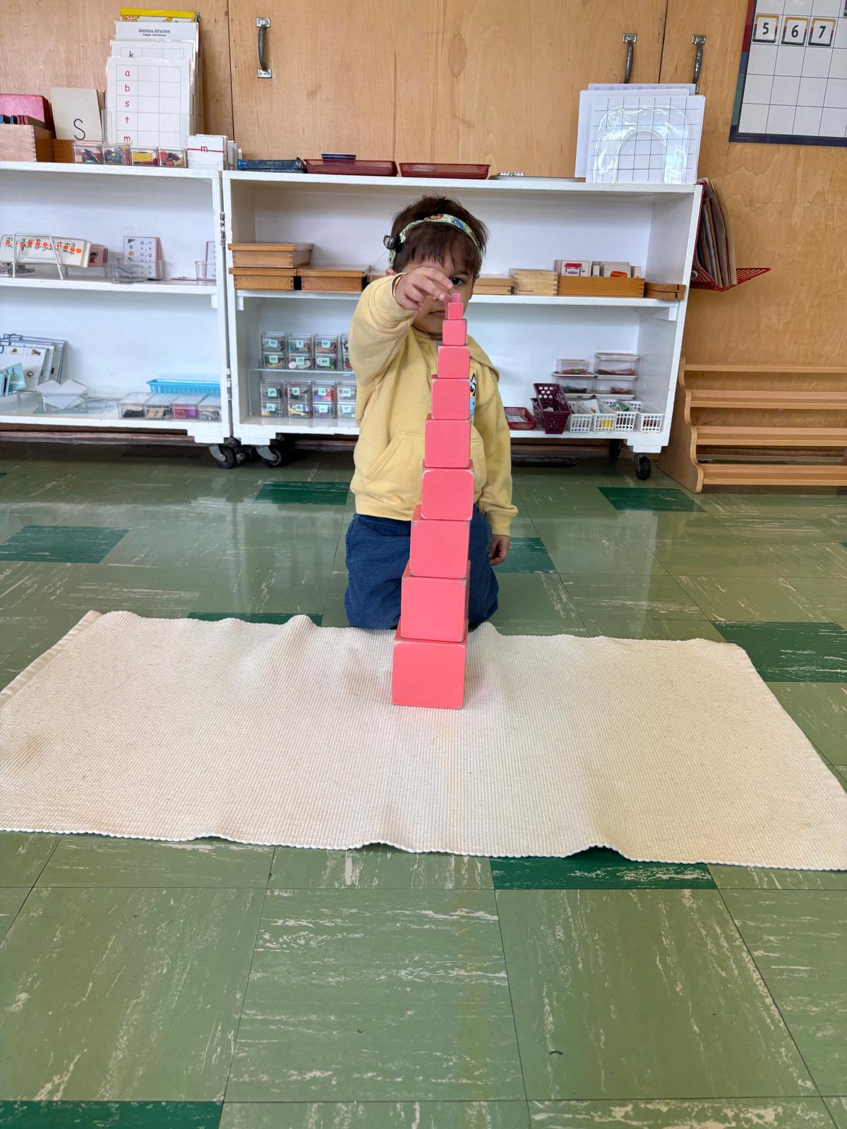 Child building the Montessori pink tower